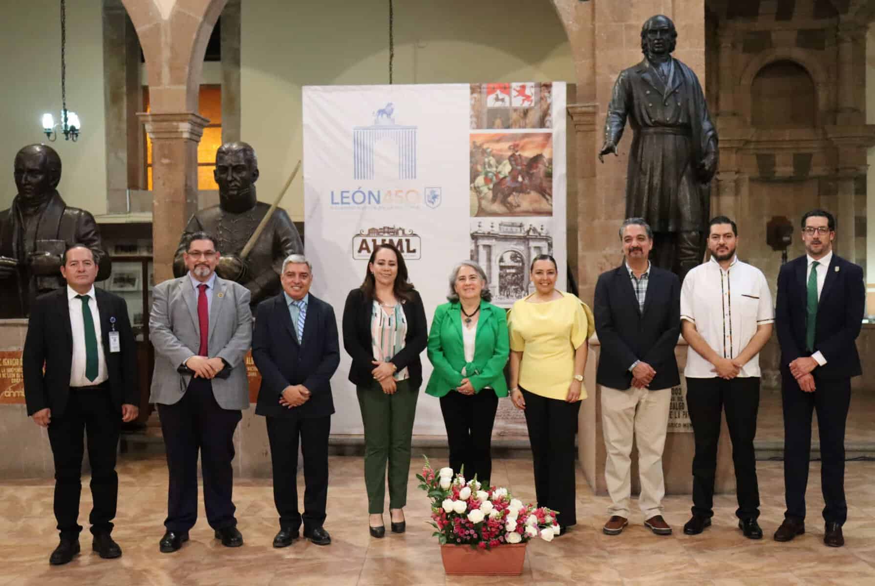 Grupo de personas en evento cultural en León, Guanajuato, con estatuas y exhibiciones históricas.