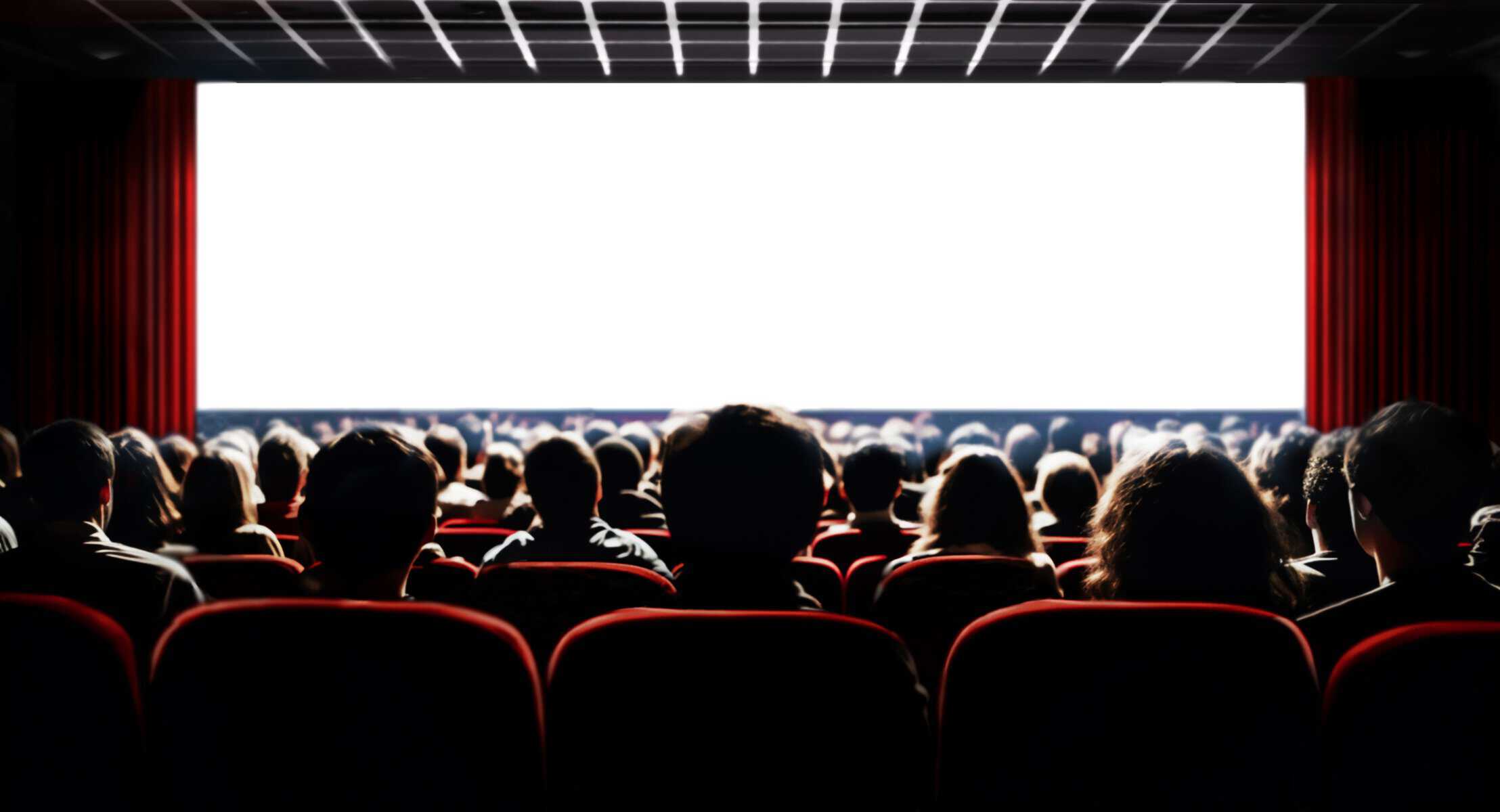 Audiencia en cine en León, Guanajuato, disfrutando de una película en un cine con pantalla grande y butacas rojas.
