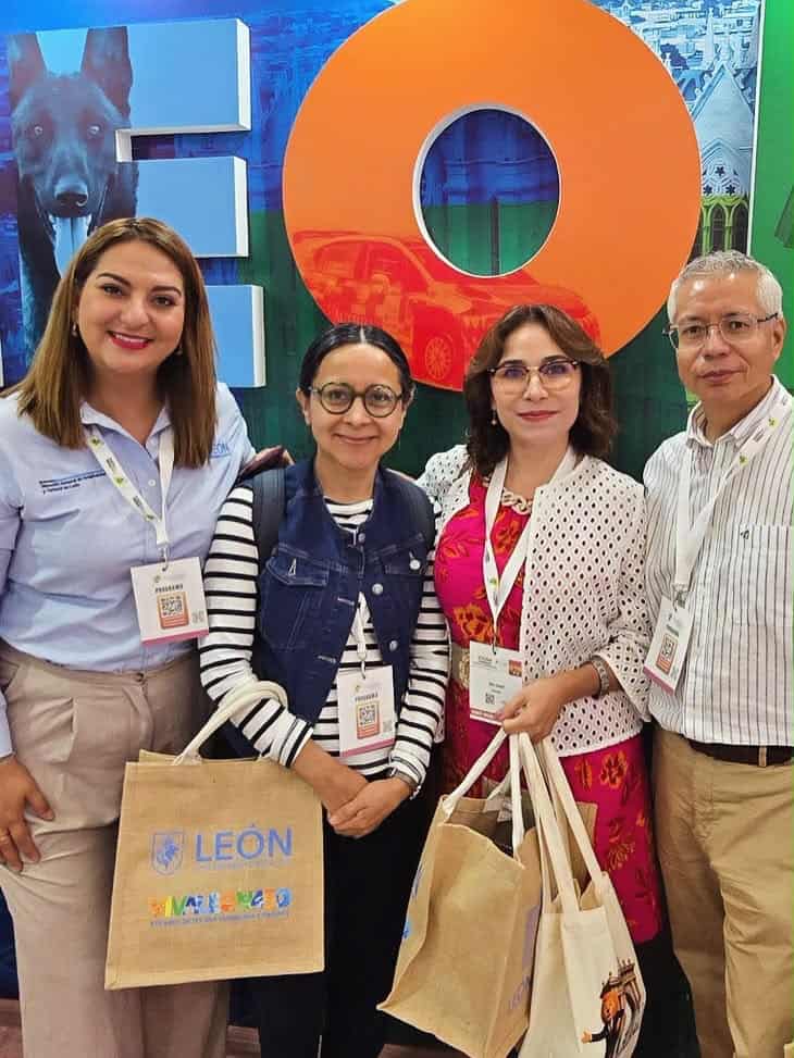 Grupo de turistas en León Guanajuato con bolsas y cartel de VIVA LEÓN, disfrutando de la ciudad y su cultura.
