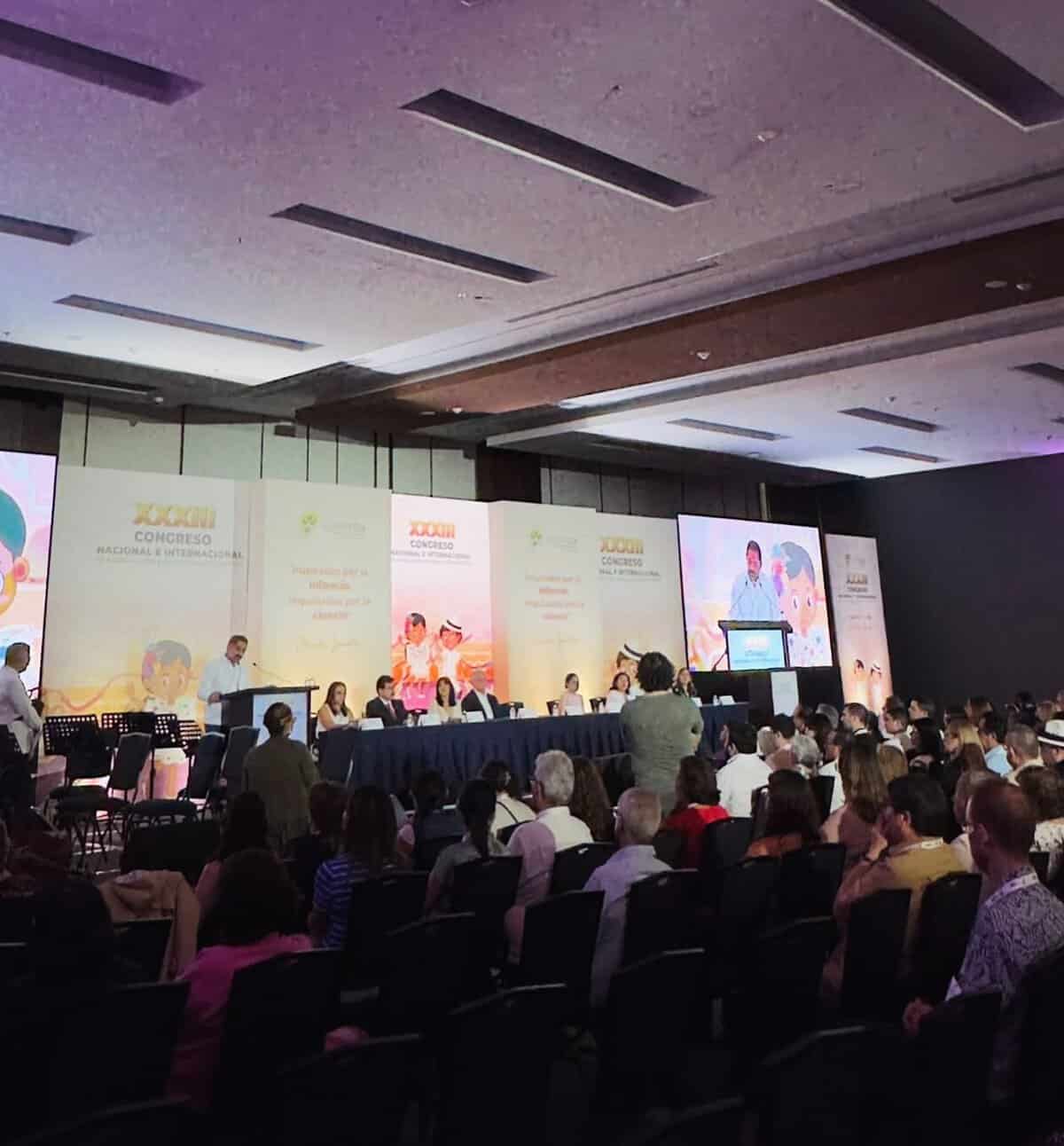 Conferencia en León, Guanajuato, sobre alergias y inmunología pediátrica, con audiencia y panel de expertos en el evento.