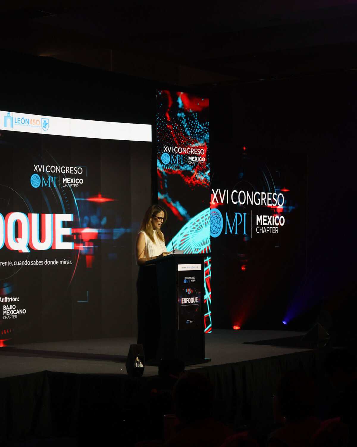 Ponente en conferencia del XVI Congreso de MPIO en León, Guanajuato, México, con pantallas y escenario moderno.