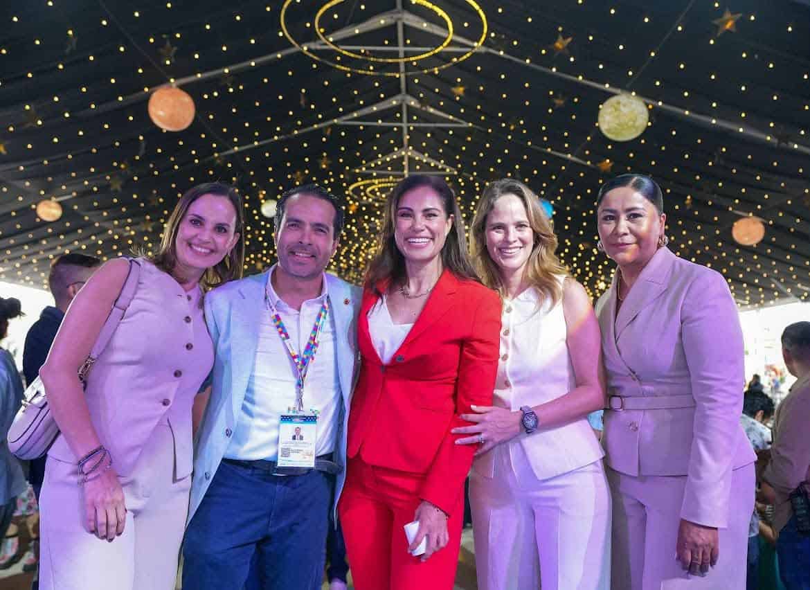Grupo de personas en evento social en León, Guanajuato, con decoración de luces y globos en el techo.