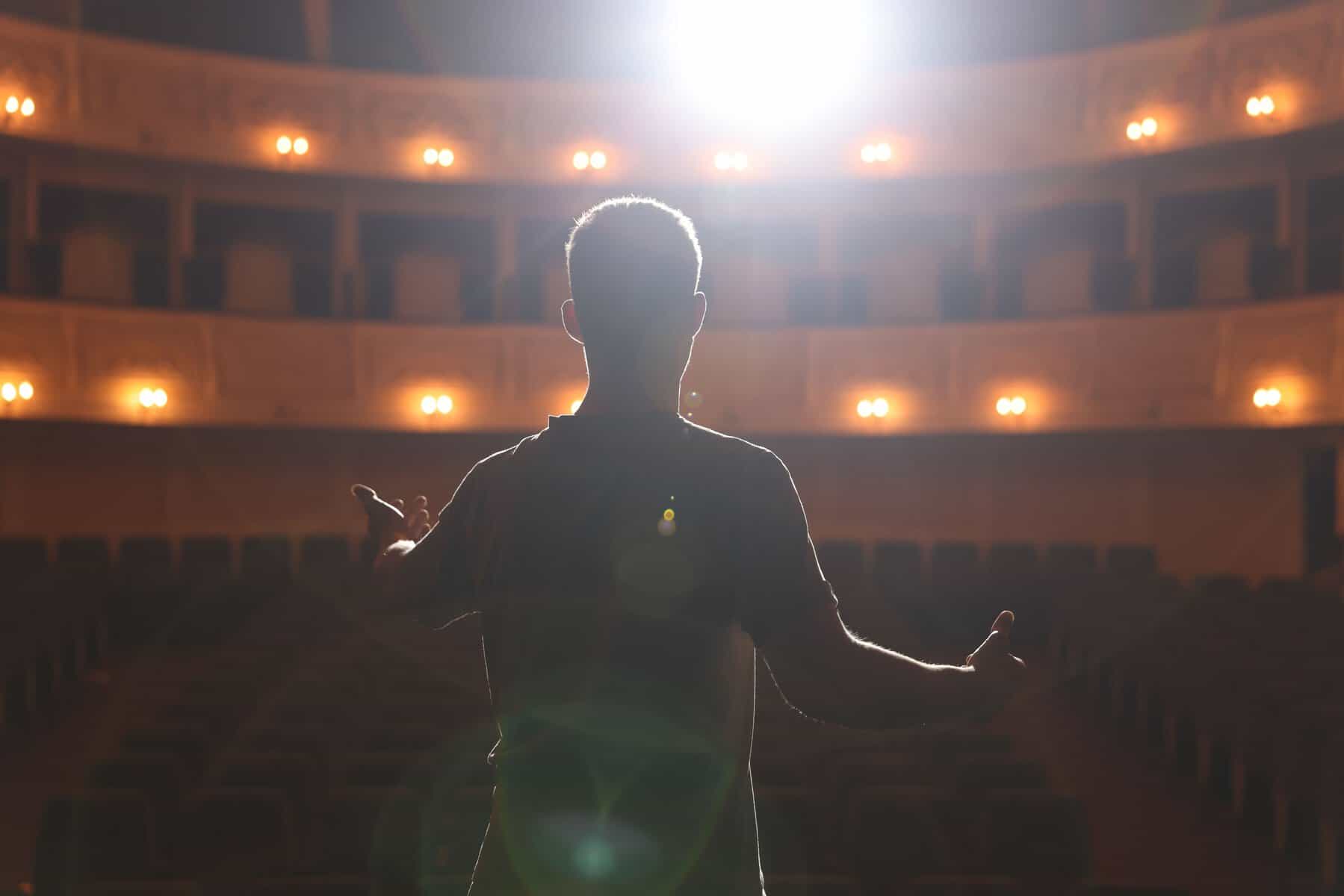 Actor en teatro de León, escenario iluminado, cultura y entretenimiento en Guanajuato, México.