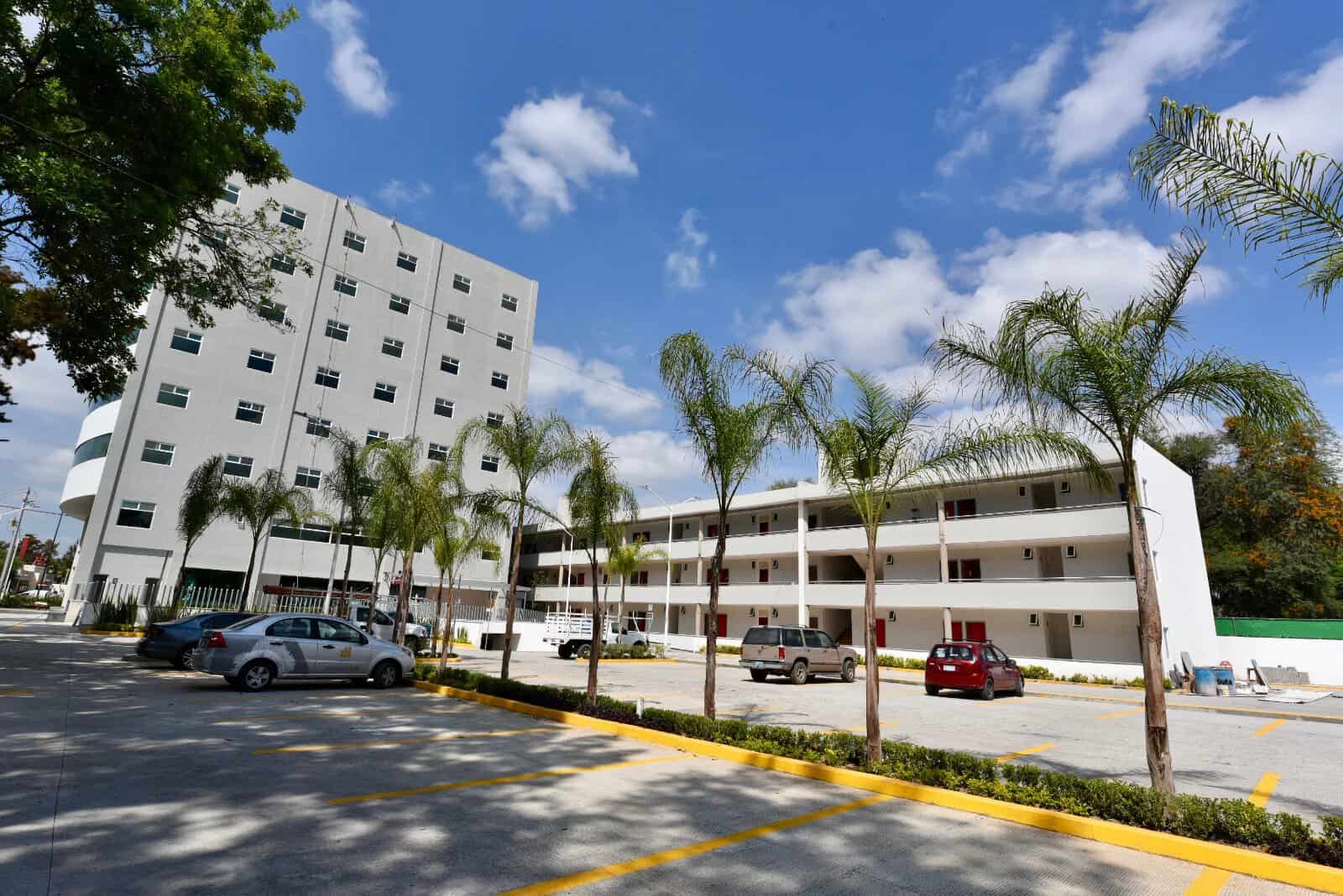 Fachada moderna del Hotel 5 Inn Plus León con palmeras y estacionamiento amplio.