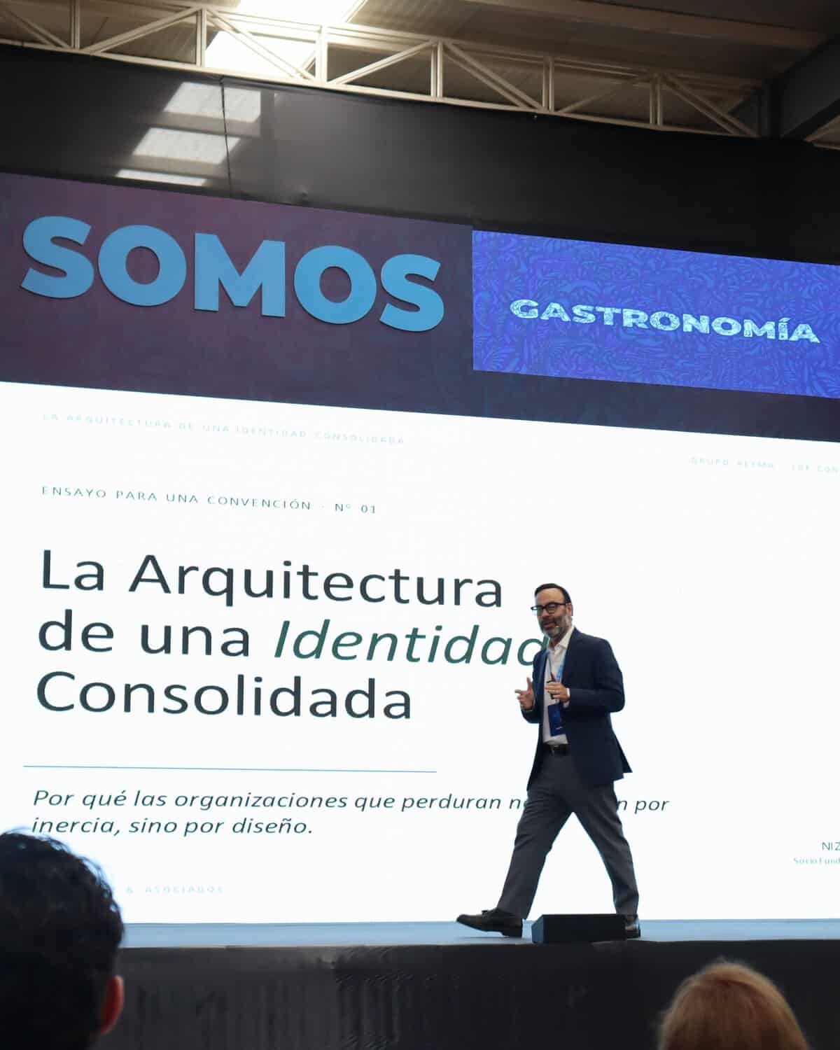 Hombre en conferencia sobre arquitectura y gastronomía en León, Guanajuato, México, en un evento cultural y profesional.