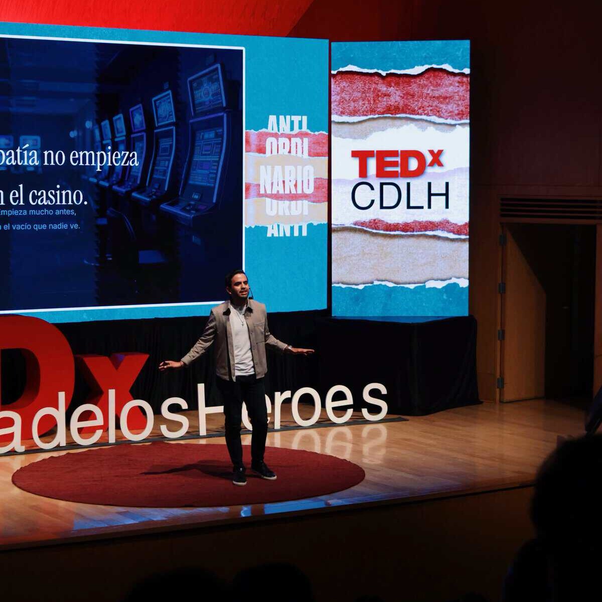 Hombre dando una charla en un escenario con pantallas grandes en TEDx León, evento de ideas y liderazgo en Guanajuato.