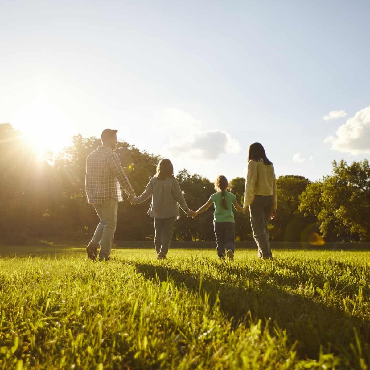 Familia paseando en parque de León, Guanajuato, México, al atardecer, con niños y adultos en un entorno natural y soleado.