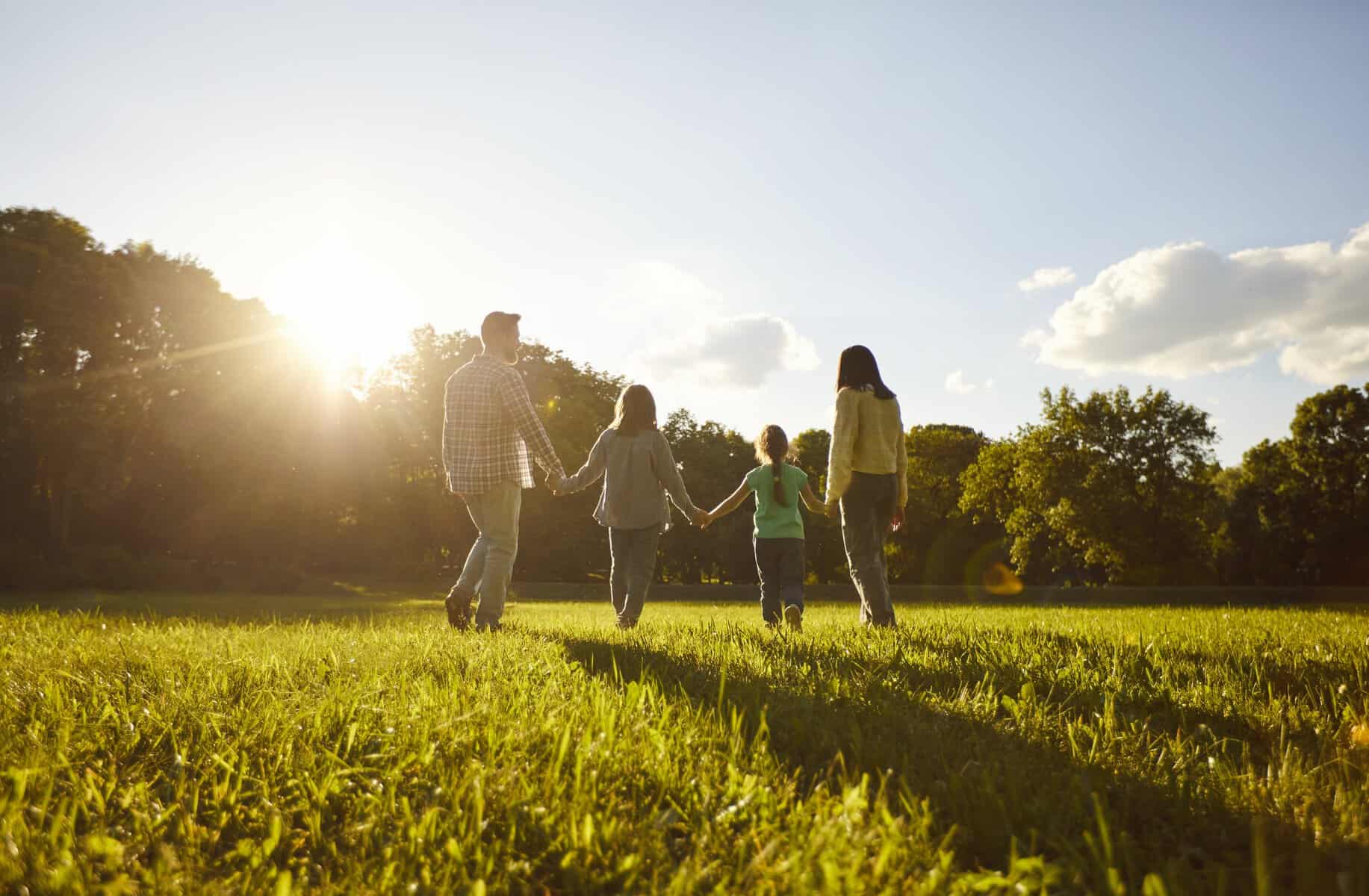 Familia paseando en parque de León, Guanajuato, México, al atardecer, con niños y adultos en un entorno natural y soleado.