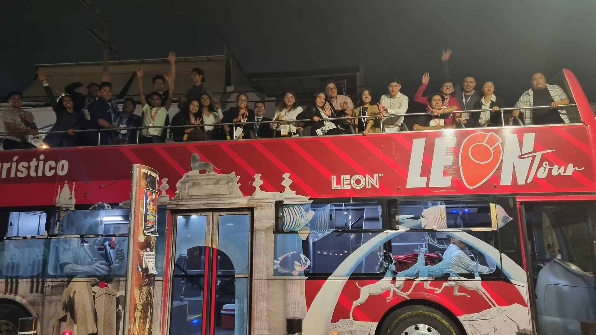 Grupo de turistas en un autobús turístico en León, Guanajuato, disfrutando de un recorrido nocturno por la ciudad.
