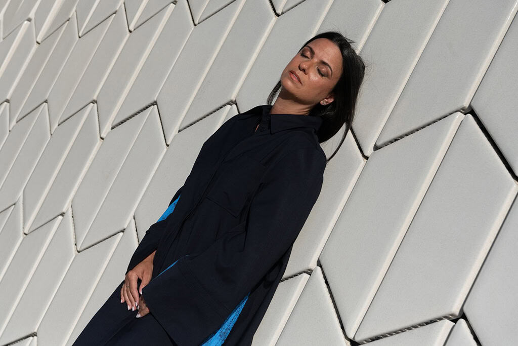 Mujer con ropa deportiva y expresi&oacute;n relajada en Le&oacute;n, Guanajuato, M&eacute;xico, en un entorno urbano moderno y arquitect&oacute;nico.