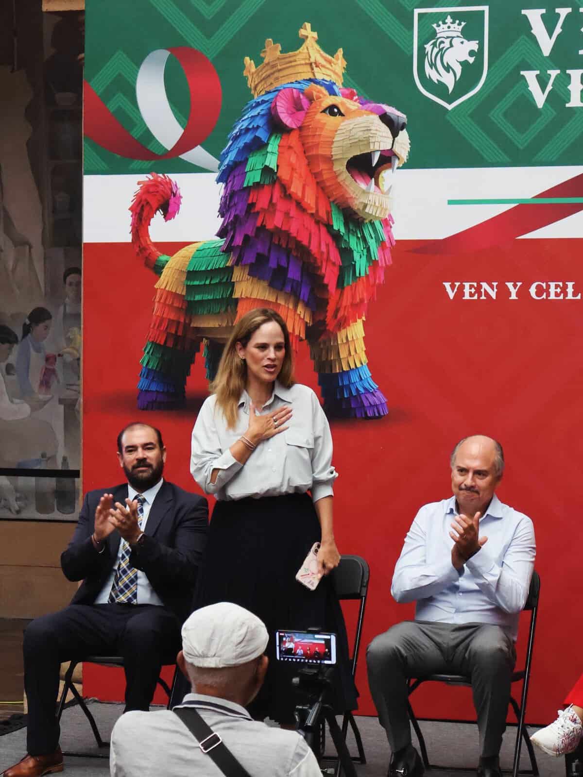 Celebración en León, Guanajuato con símbolo del león multicolor y autoridades en evento cultural.