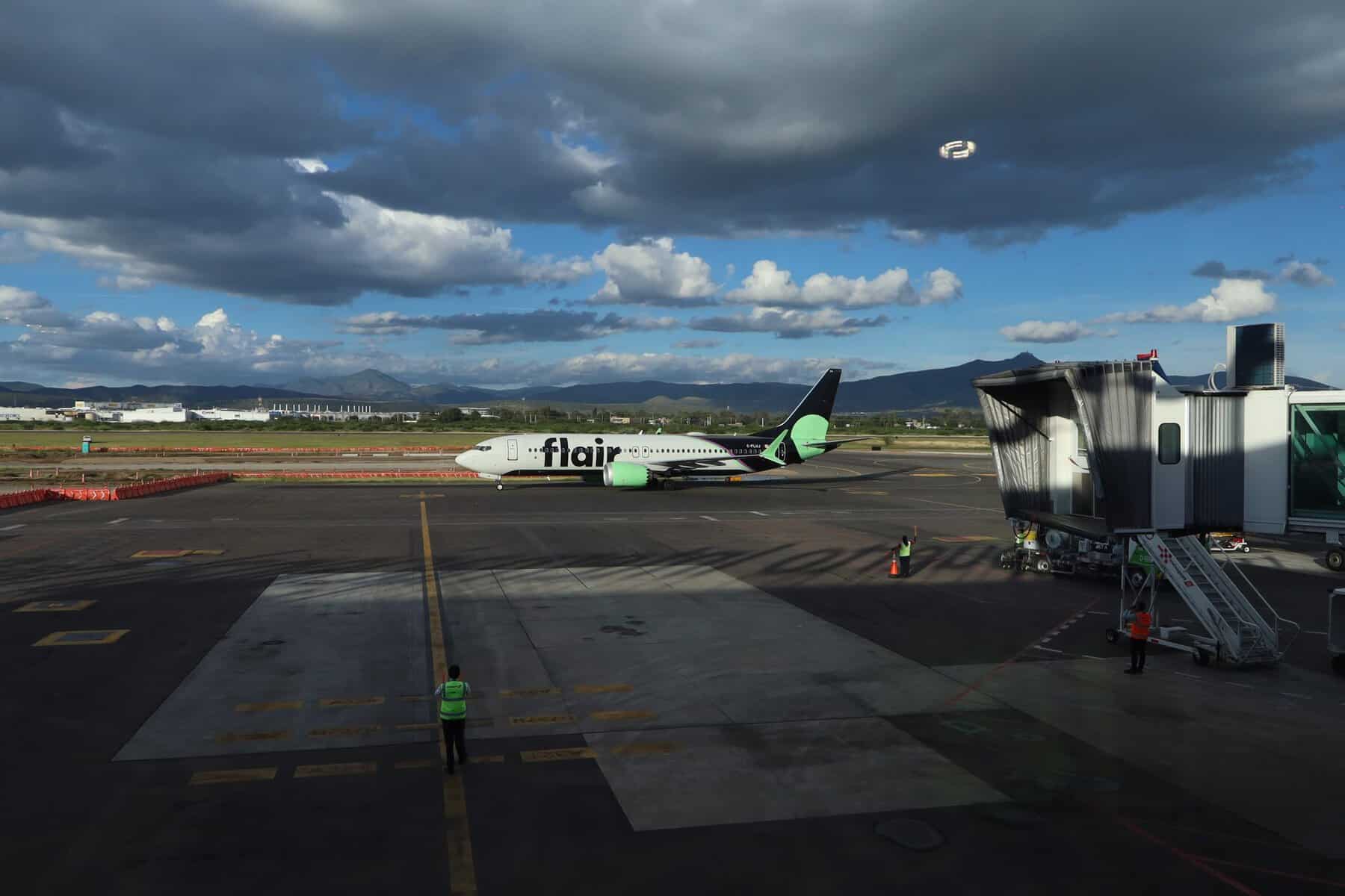 Avi&oacute;n de Flair Airlines en aeropuerto de Le&oacute;n, Guanajuato, con cielo nublado y monta&ntilde;as al fondo.