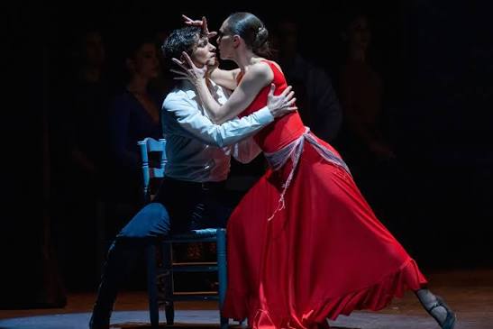 Pareja bailando flamenco en Le&oacute;n, Guanajuato, M&eacute;xico, en un escenario oscuro, mostrando pasi&oacute;n y tradici&oacute;n cultural.