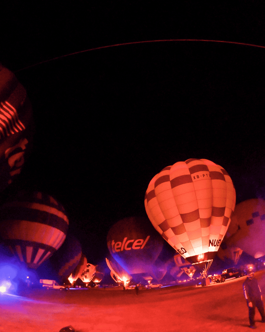 Hot air balloons glowing at night during the 2026 International Balloon Festival in León, Guanajuato.