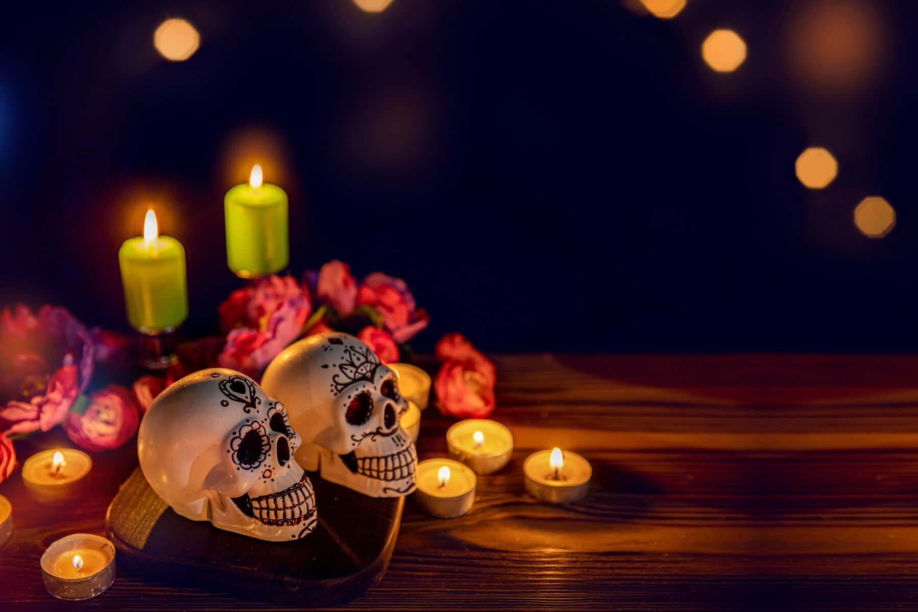 Calaveras decoradas con velas y flores en ambiente festivo del D&iacute;a de Muertos en Le&oacute;n, Guanajuato.