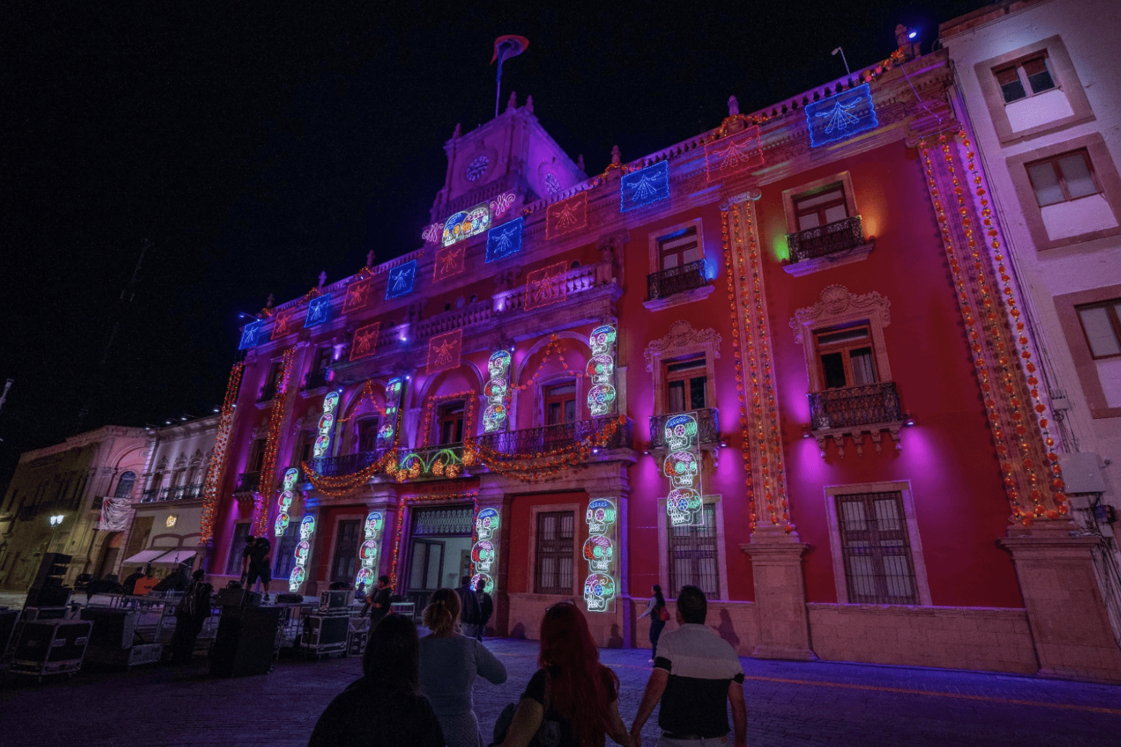 Fachada del Palacio de León iluminada con luces de colores durante el Festival de la Muerte 2026.