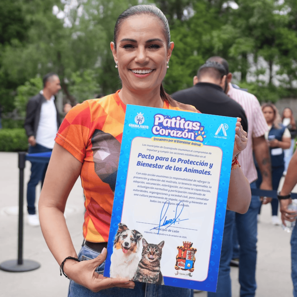 Mujer en León mostrando certificado de protección y bienestar animal en evento comunitario.