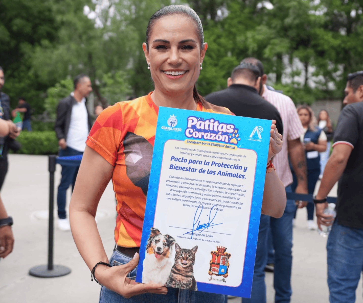 Mujer en Le&oacute;n mostrando certificado de protecci&oacute;n y bienestar animal en evento comunitario.